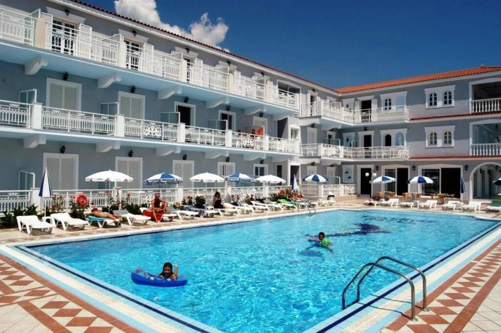 Un hôtel doté d’une piscine, de plusieurs balcons et de parasols.