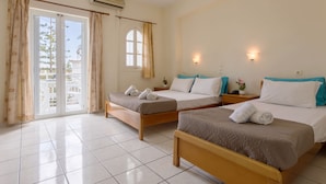 A hotel room with two beds, a sliding glass door to the outside, and a small window. - Laganas Holidays Hotel (Zakynthos)