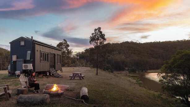A cabin with a fire pit, outdoor seating, and a view of a lake. - Tiny Thomas Summary: (Upper Colo)