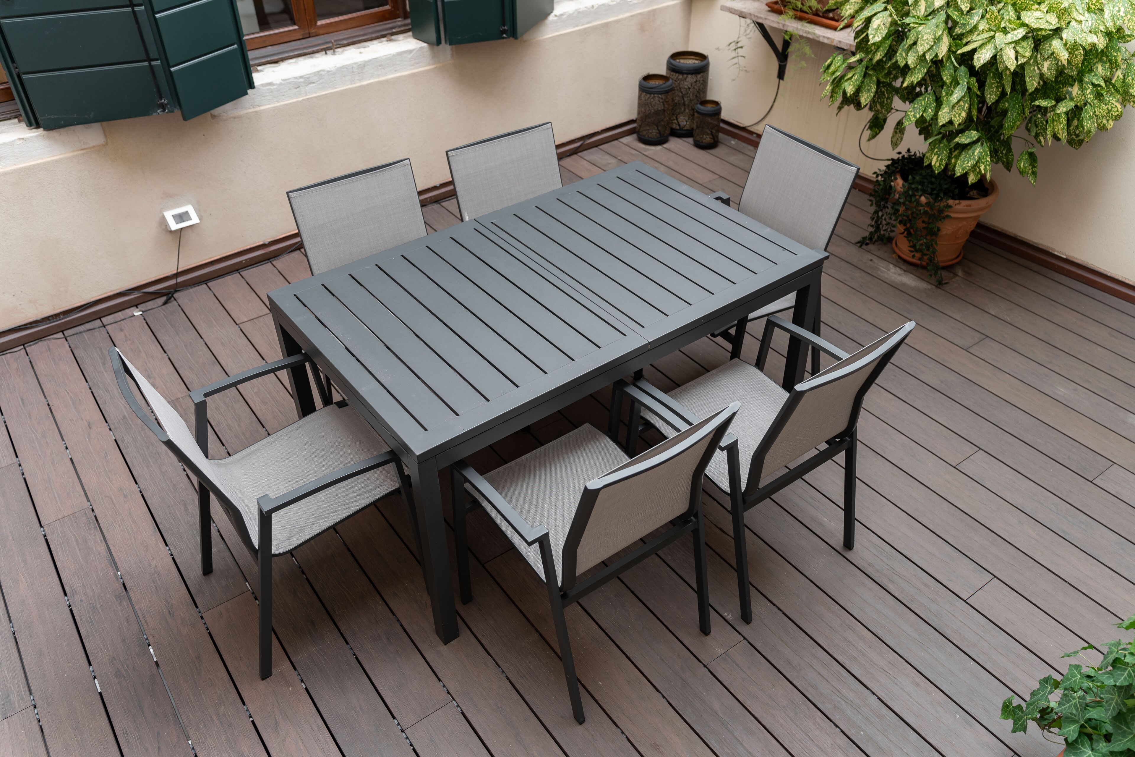 A patio with a rectangular table and six chairs.