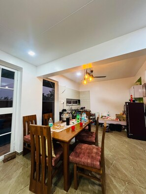 Enjoy meals in the kitchen and dining area with stainless steel appliances, a microwave, and a refrigerator. The dining table seats guests with a view of the outside.