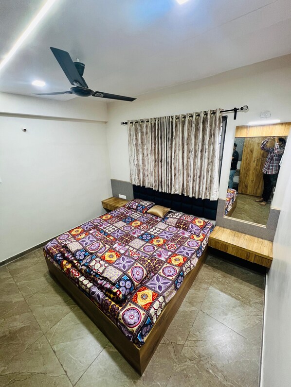 Restful retreat with a large bed, ceiling fan, and mirror.
