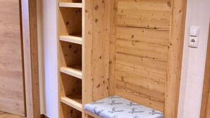 Een houten kamer met een ingebouwde bank en planken.