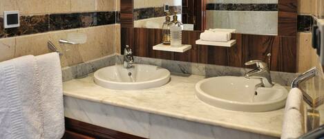 A bathroom with two sinks, a mirror, and a towel rack.