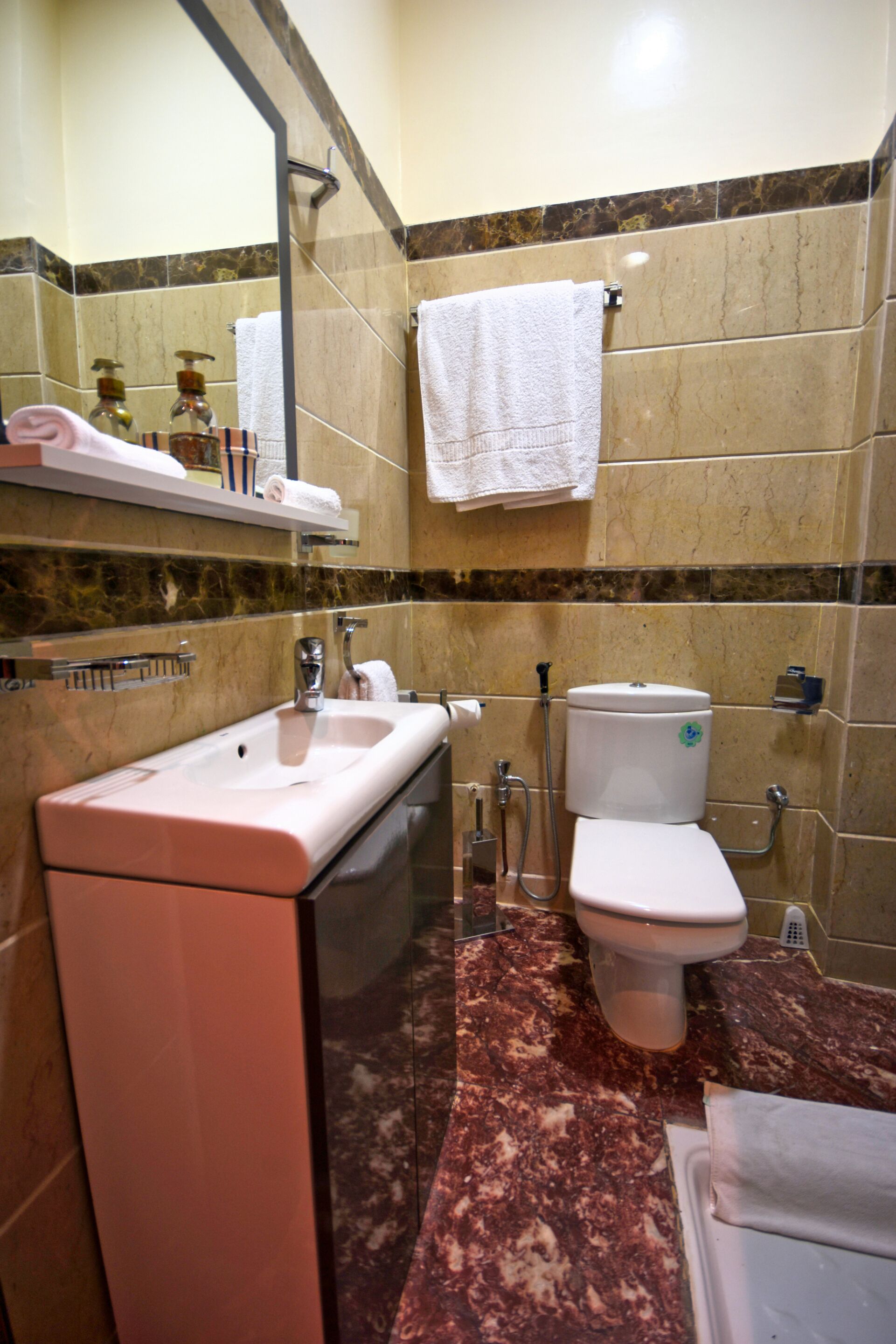 Une salle de bain équipée d’un lavabo, d’un miroir, de toilettes et d’une douche.