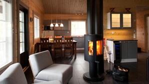 A cozy living room with a fireplace, a dining area, and a kitchen with a stove.