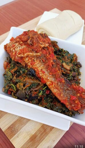 Savor a delicious fish dish served with fresh greens.