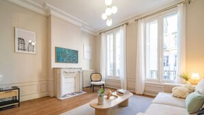 A living room with a fireplace, a sofa, a coffee table, and a chair. - Le Champagne Central (Reims)
