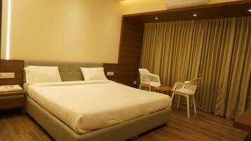 Una habitación de hotel con una cama grande, un escritorio y una silla.