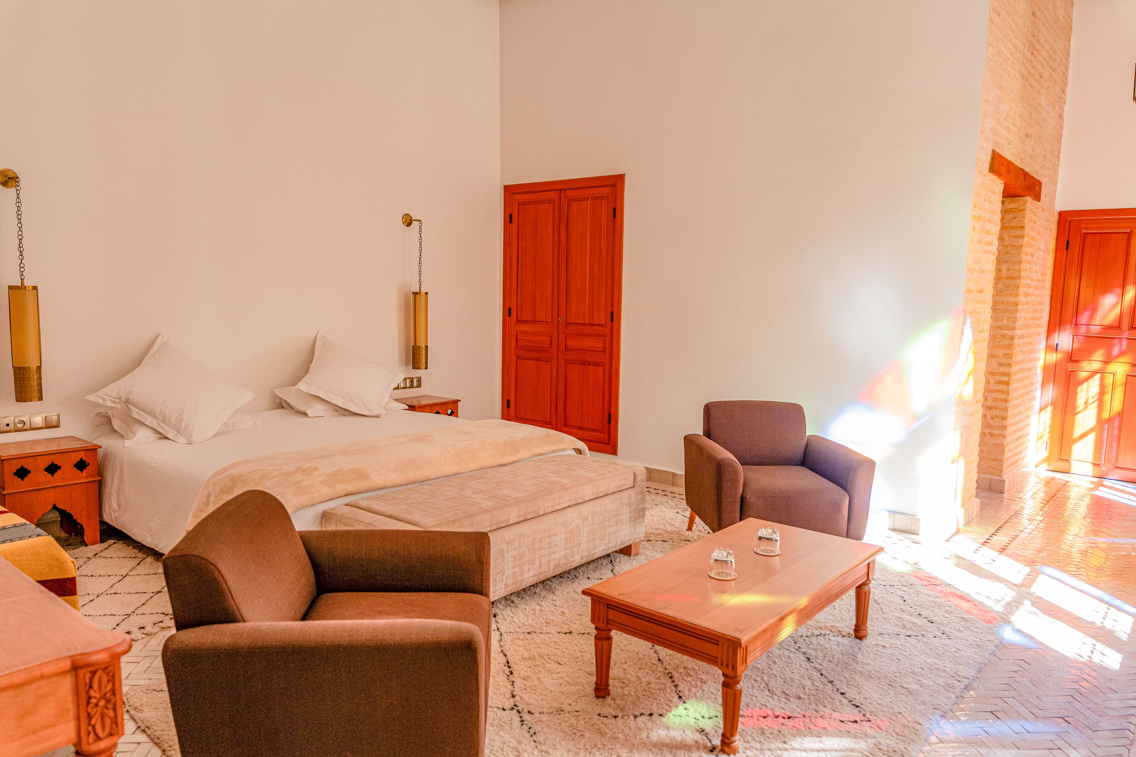 A bedroom with a bed, a sofa, a coffee table, and a nightstand.
