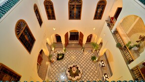 A courtyard with a tiled floor, arched doorways, and a central fountain. - Riad Al Ansari (Fes)
