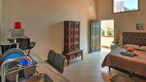 A bedroom with a bed, a nightstand, a cabinet, a desk with a computer, and a window. - Casa las Mariposas Bungalow 10 (Los Ayala)