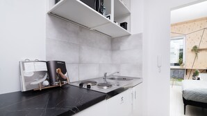 A modern kitchen with white cabinetry, a black marble countertop, and a built-in stove. - EASY RENT Apartments - Smart 005 (Lublin)