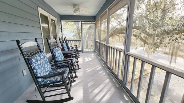 A covered porch with rocking chairs and a view of trees. - Nice Pet Friendly Home in N. Litchfield. Easy Beach Access, Quiet Location (Pawleys Island)