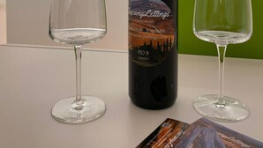 A wine bottle labeled "Pio II Chianti" on a table with two empty wine glasses. - MontepulcianoLettings (Montepulciano)