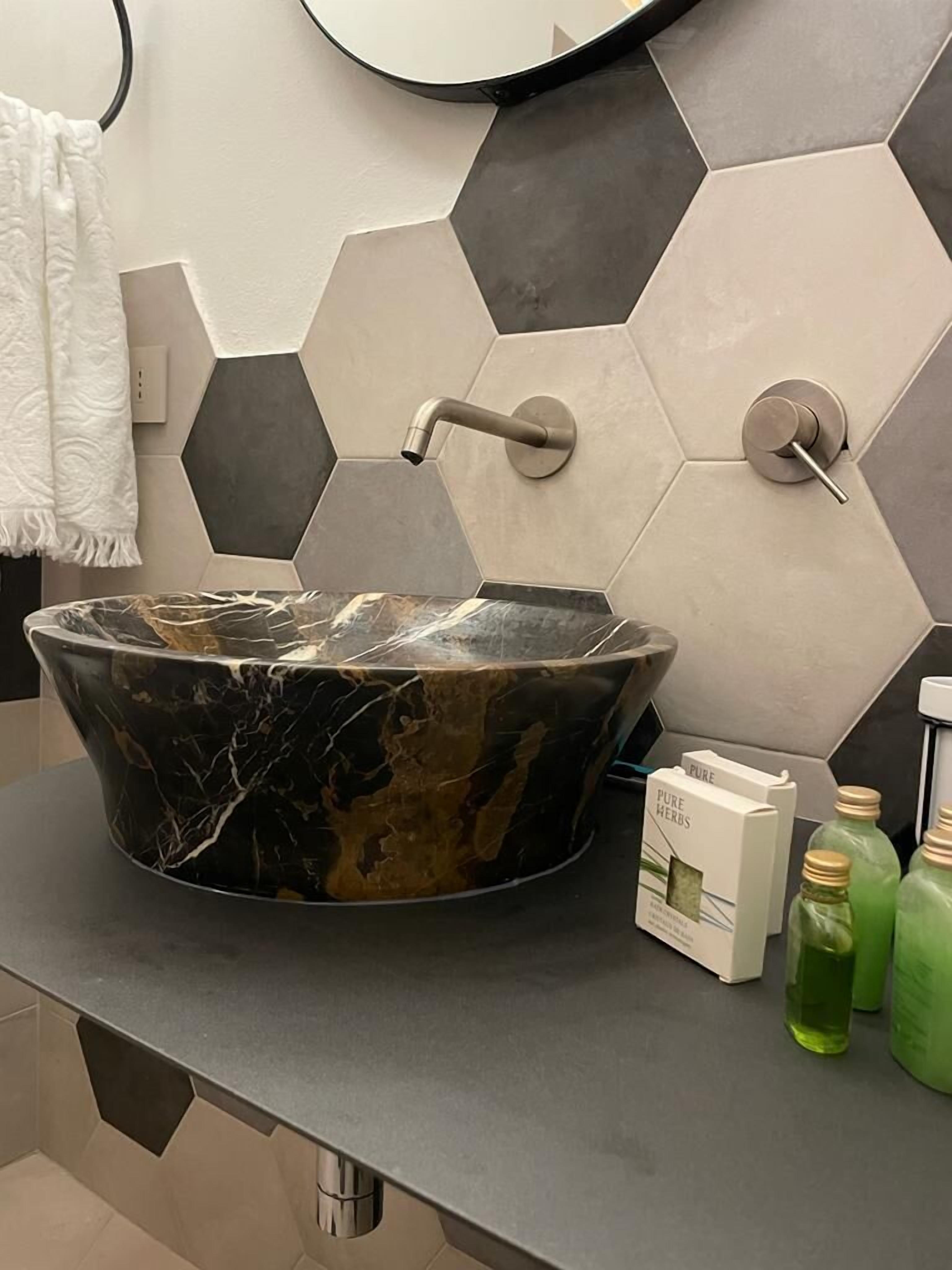 Een badkamer met een marmeren wastafel, een handdoek en een spiegel.