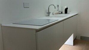 A modern kitchen with a built-in sink, a stove, and a window above the sink. - MontepulcianoLettings (Montepulciano)