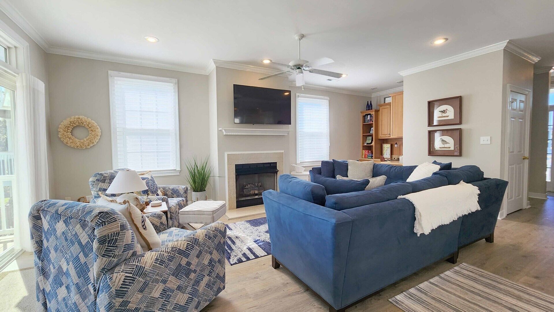 A living room with a blue sofa, patterned armchair, and a fireplace.