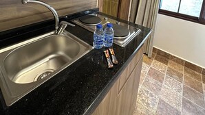 A modern kitchen with a microwave, double sink, and two water bottles on the counter. - 7 Antica Jabalal-lwebdeh (Amman)