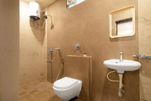 Bathroom features a toilet, sink, and shower area with handheld showerhead.