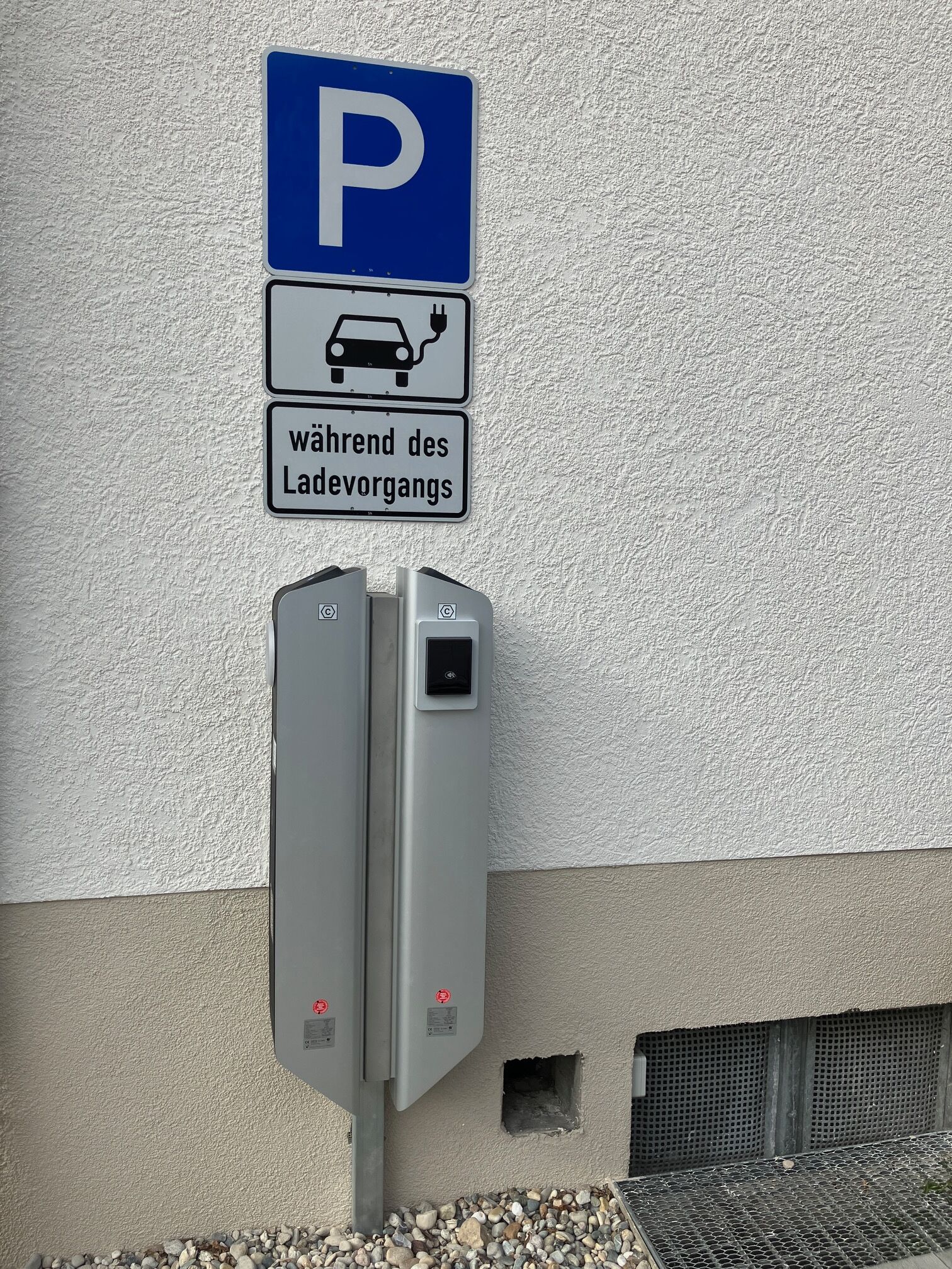 A parking sign with a car and plug symbol, and a German text below.