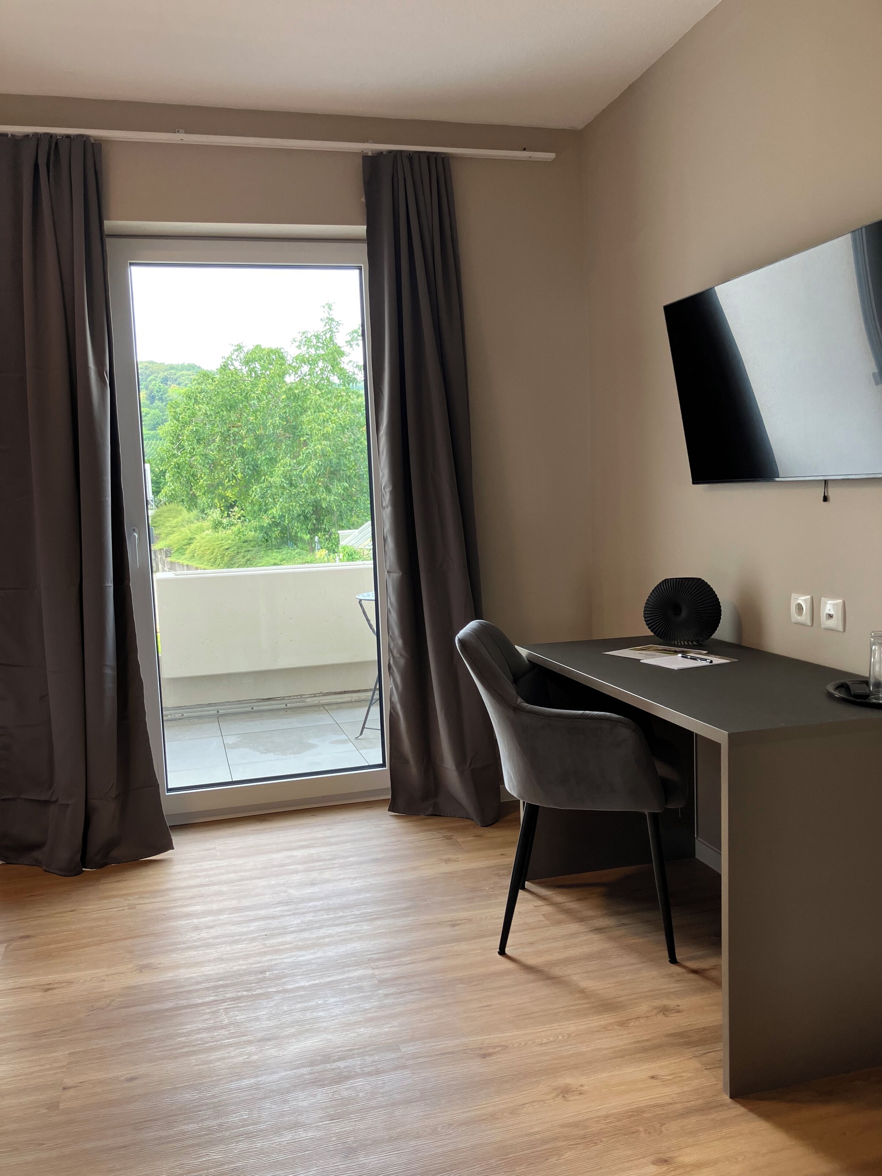 Une chambre moderne équipée d’un bureau, d’une chaise et d’un téléviseur fixé au mur.