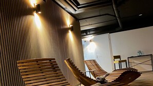 Un espacio interior moderno para relajarse, con sillones de madera y techo inclinado.
