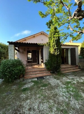 Stroll up to the charming entrance, flanked by columns, and step into a serene natural setting.