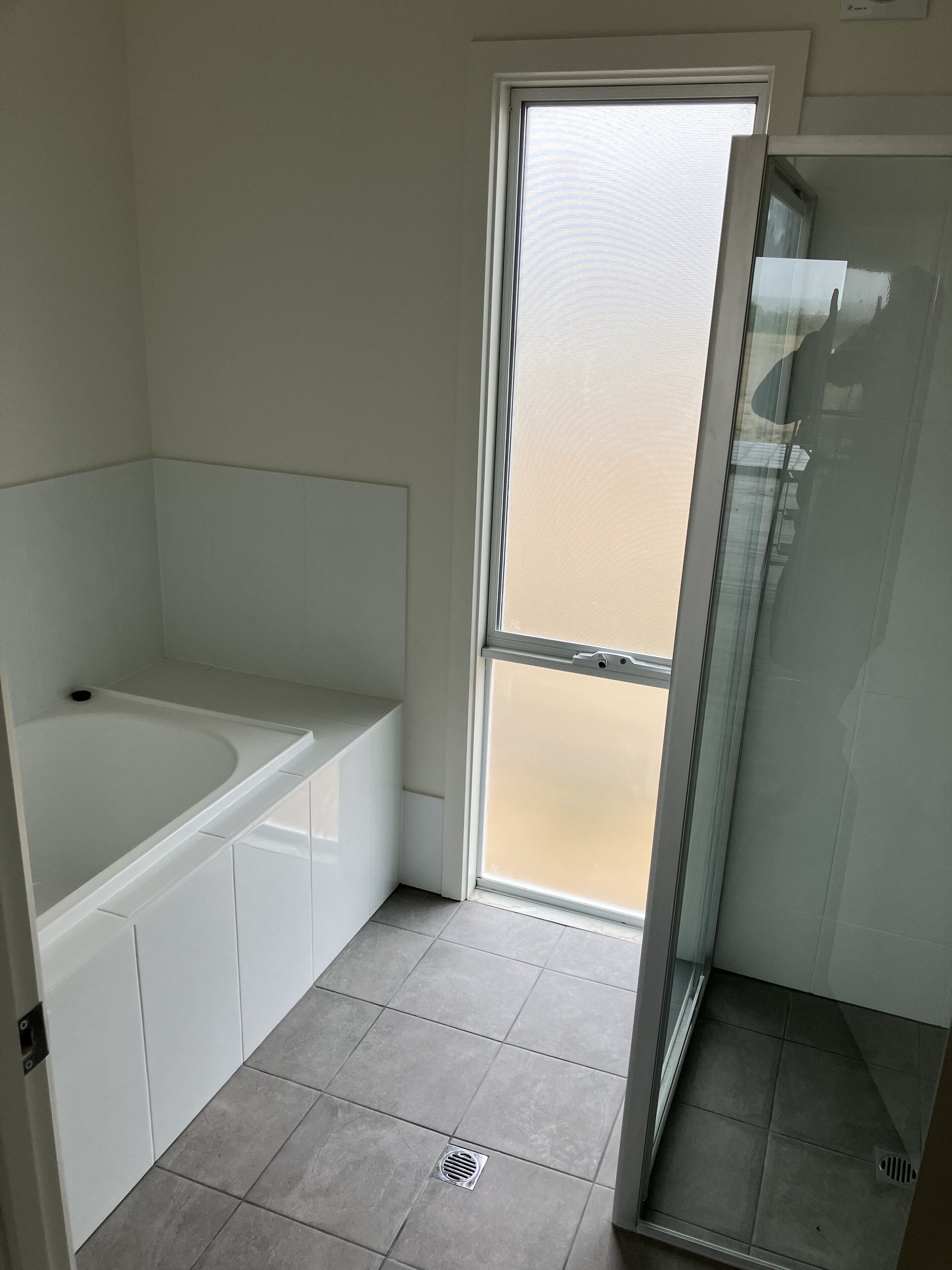 A bathroom with a bathtub, a shower, and a glass door leading to a balcony.