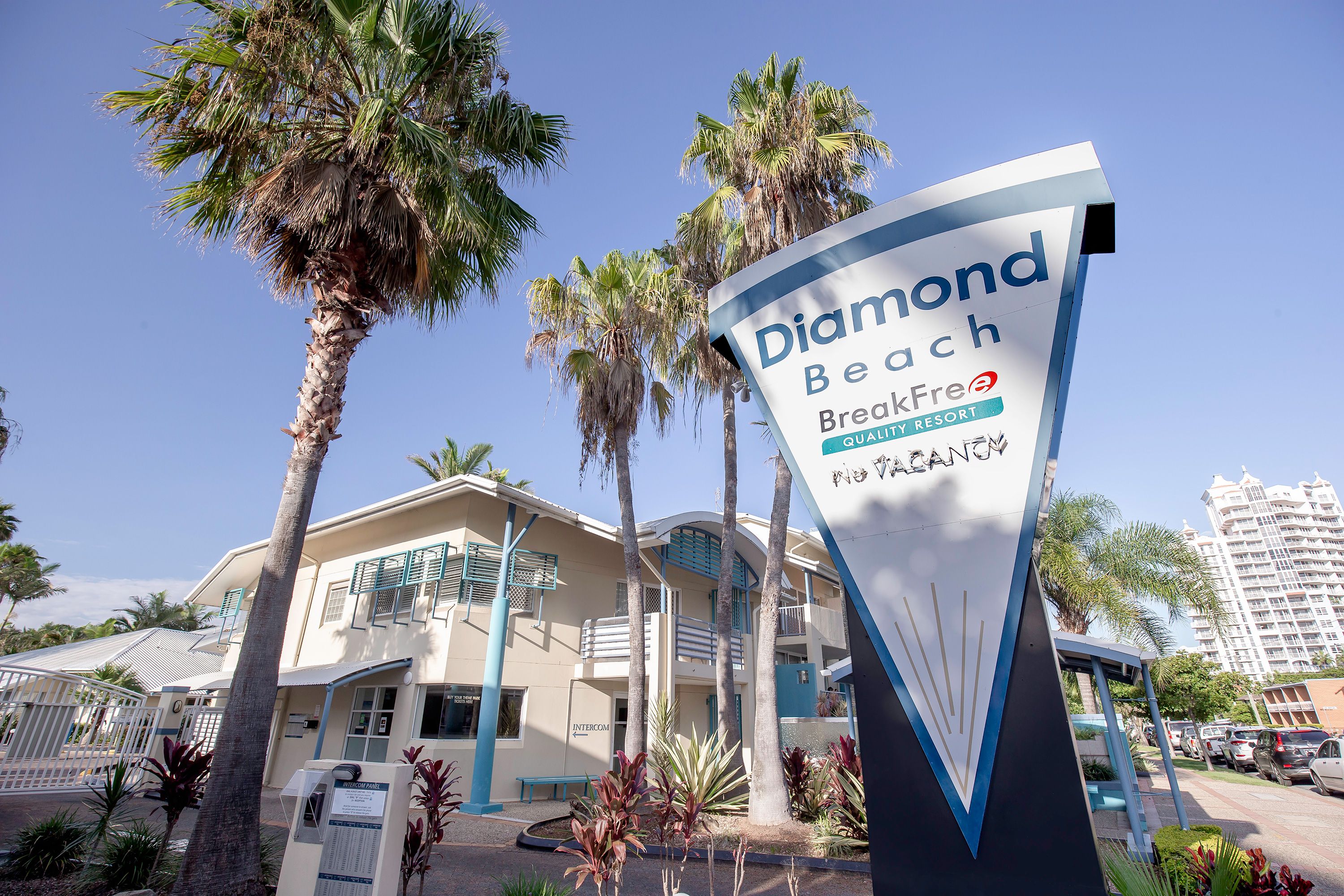 A hotel sign with 'Diamond Beach BreakFree Quality Resort' and palm trees.