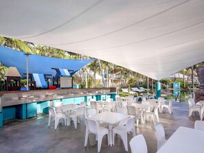 An outdoor pool area with a bar, white plastic chairs, and tables. - Breakfree Diamond Beach Broadbeach (Gold Coast)