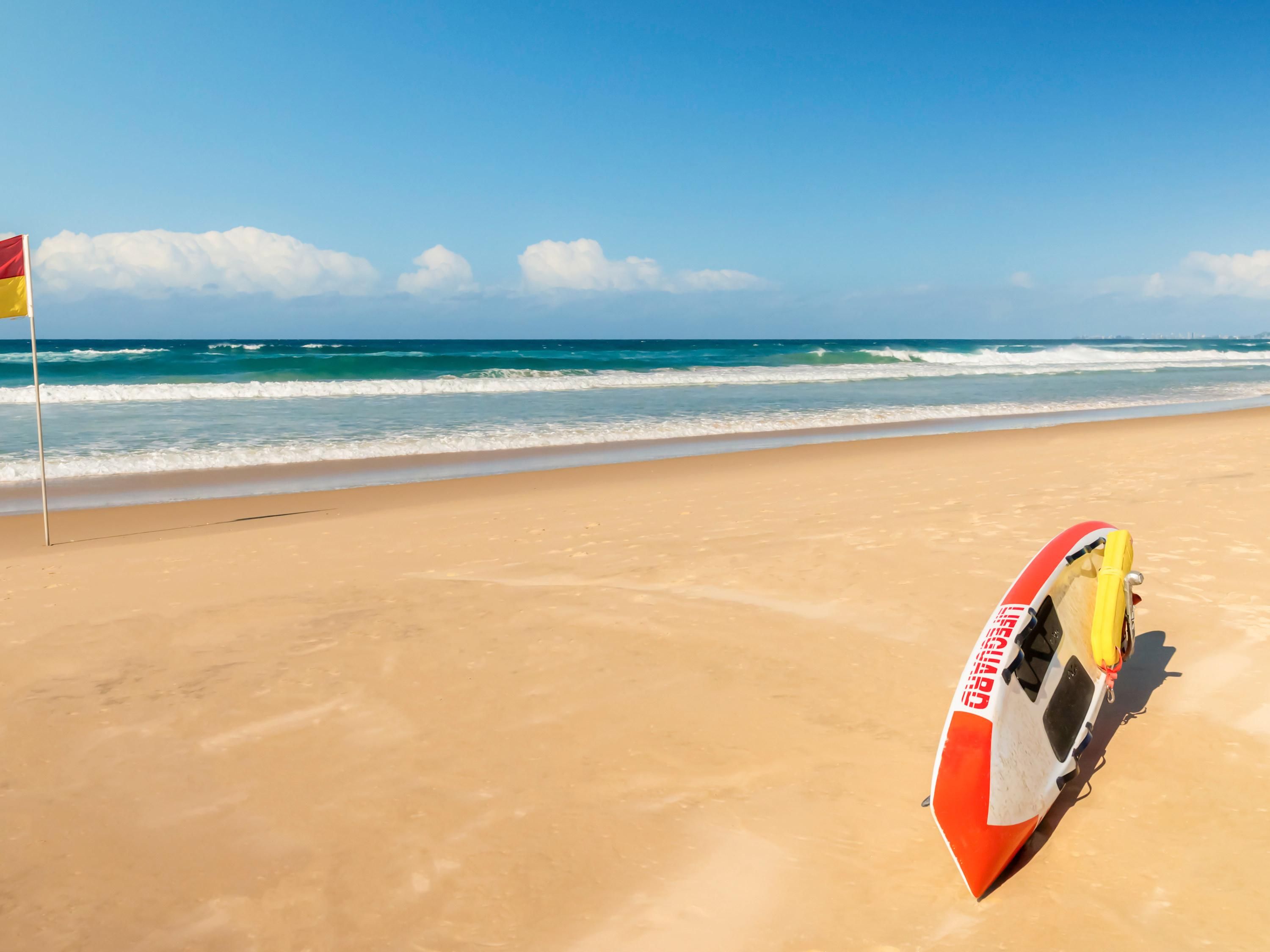 A beach with a lifeguard stand and flag.