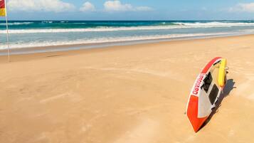 A beach with a lifeguard stand and flag.