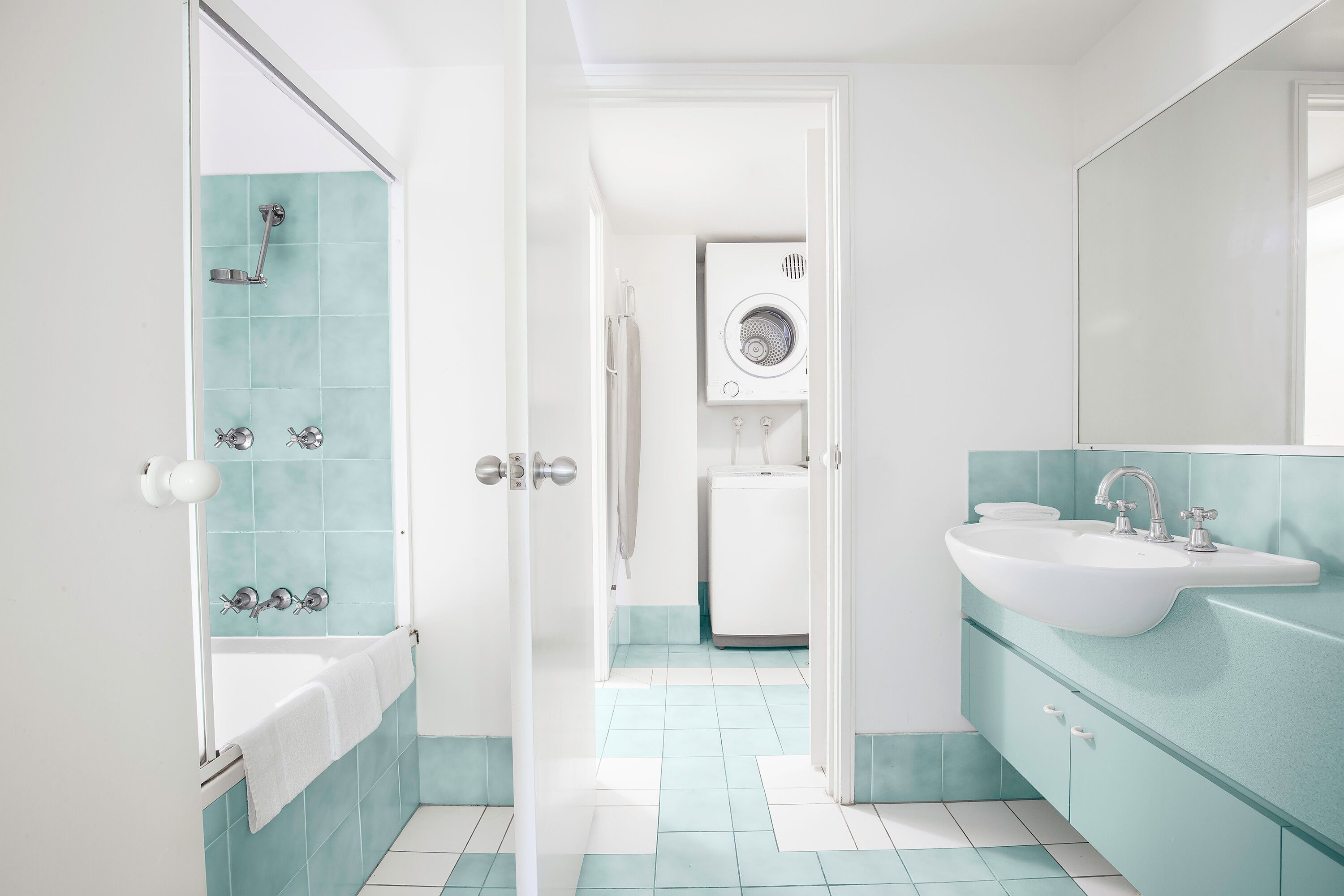 Ein Badezimmer mit Badewanne, Waschbecken und Waschmaschine.