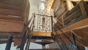 A wooden staircase with metal railings leading to a higher floor.