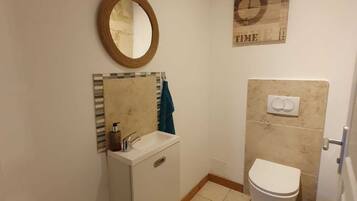 A small bathroom with a toilet, sink, and mirror.