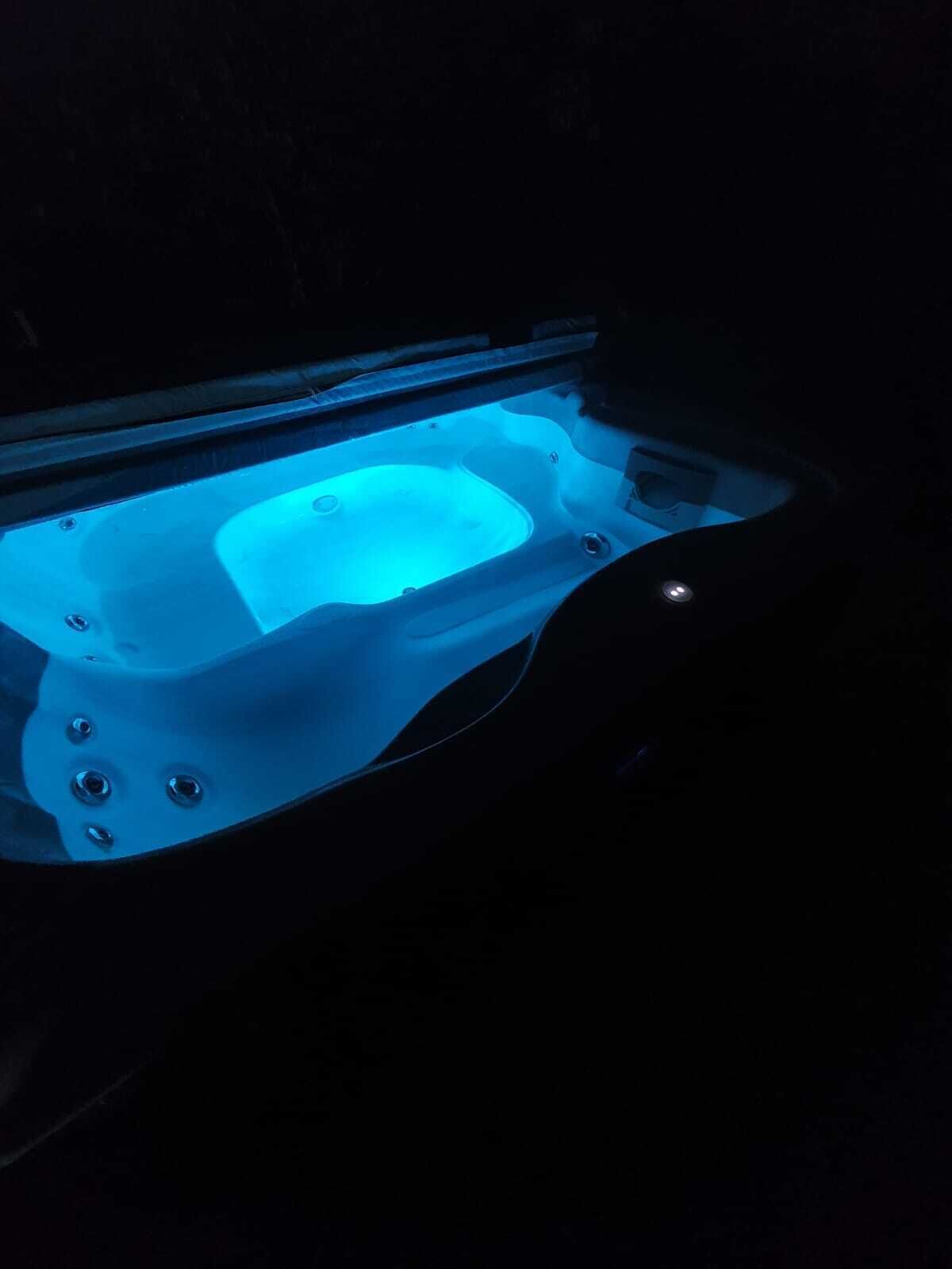 A hot tub illuminated by blue lighting.