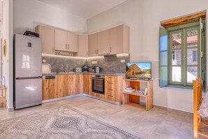 Cozinha moderna com forno embutido, geladeira e ilha de madeira com pia.