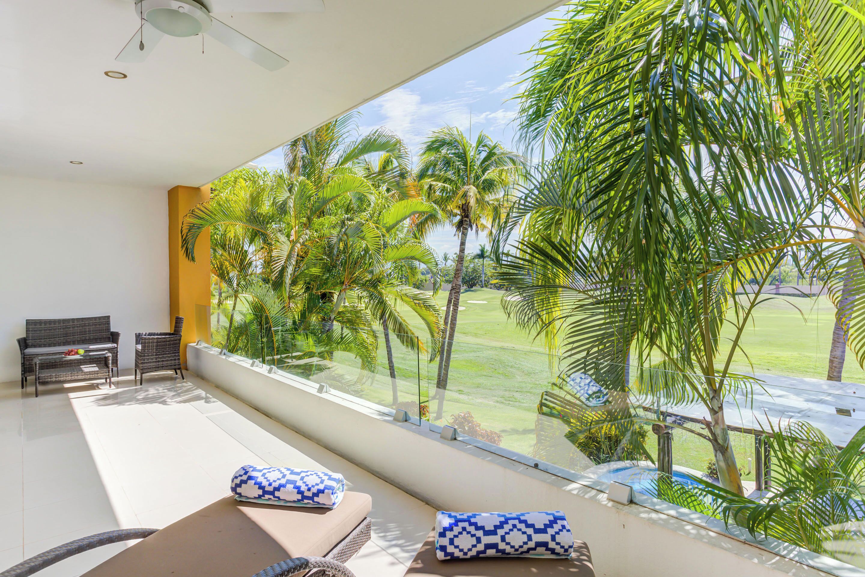 A modern room with a large window overlooking a lush garden and a pool.