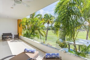 Una habitación moderna con un amplio ventanal que da a un exuberante jardín y una piscina.