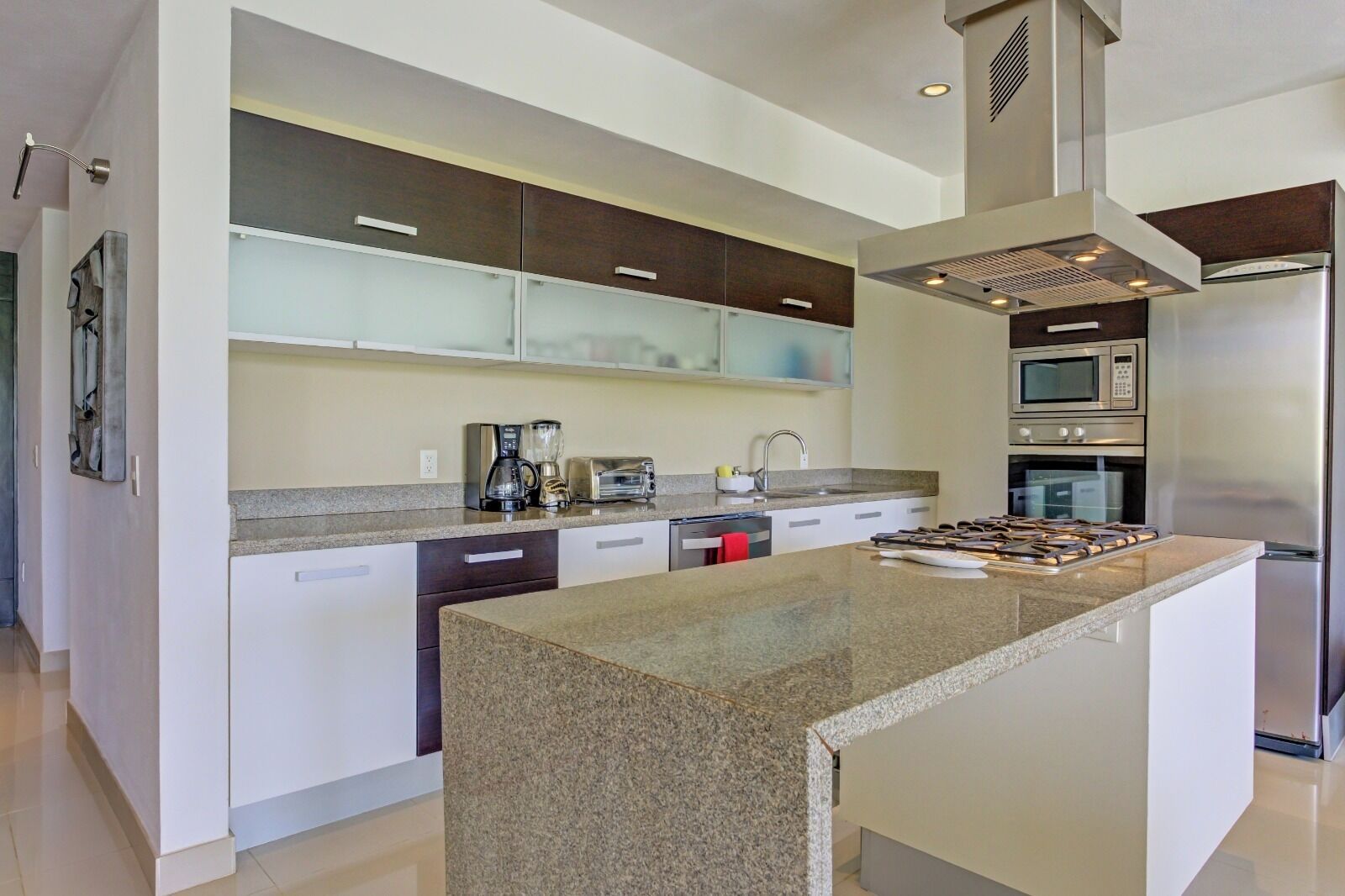A modern kitchen with a central island, stainless steel appliances, and a minimalist design.