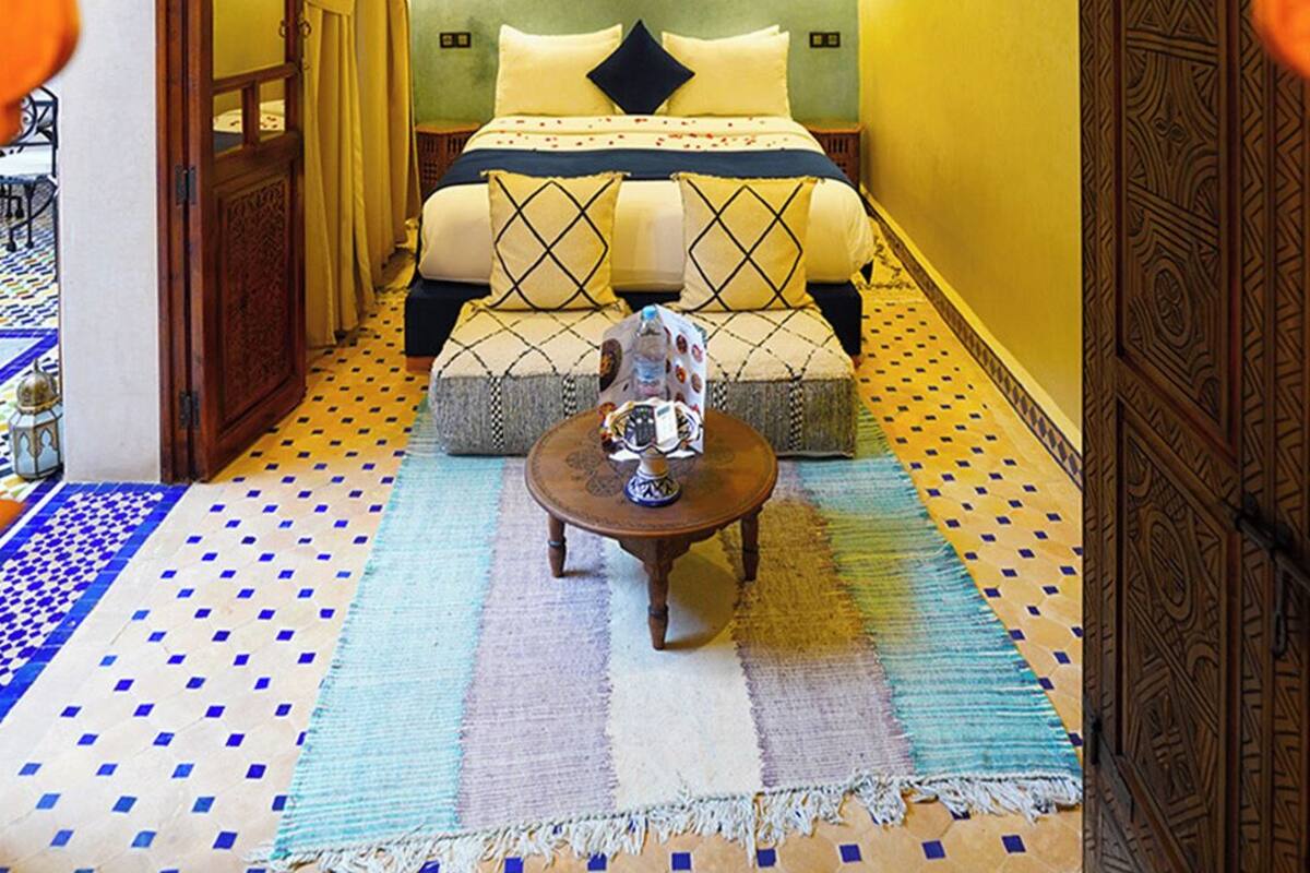 Una habitación acogedora con una cama, una mesita pequeña y un techo decorativo.