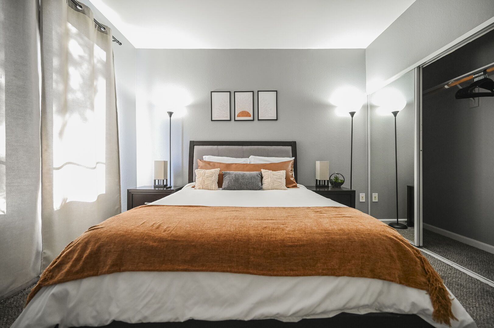 Et moderne hotelværelse med en stor seng, to sengeborde, et natbord og et garderobeskab.