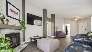 A modern living room with a fireplace, a flat-screen TV, a sectional sofa, and a coffee table. - SVS: 3BD/2BA Residential Home | Quiet Neighborhood | Sleeps 6 (Las Vegas)