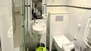 A bathroom with a glass shower enclosure, a sink, a toilet, and a mirror. - A Great Ramblas and Sea (Barcelona)