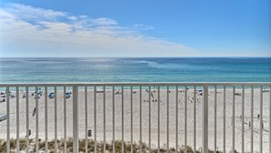 A beach with a white railing, clear blue sky, and calm sea. - Shores of Panama 503~End Unit 3 Bdrm (Panama City Beach)