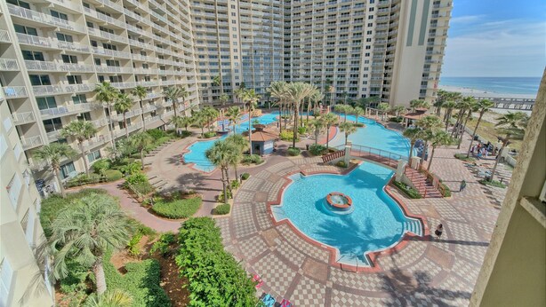 A high-rise hotel with multiple balconies, a central swimming pool, and a beach view. - Shores of Panama 503~End Unit 3 Bdrm (Panama City Beach)