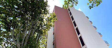 A hotel with a modern design, featuring a prominent red and white facade, large windows, and a covered outdoor area.