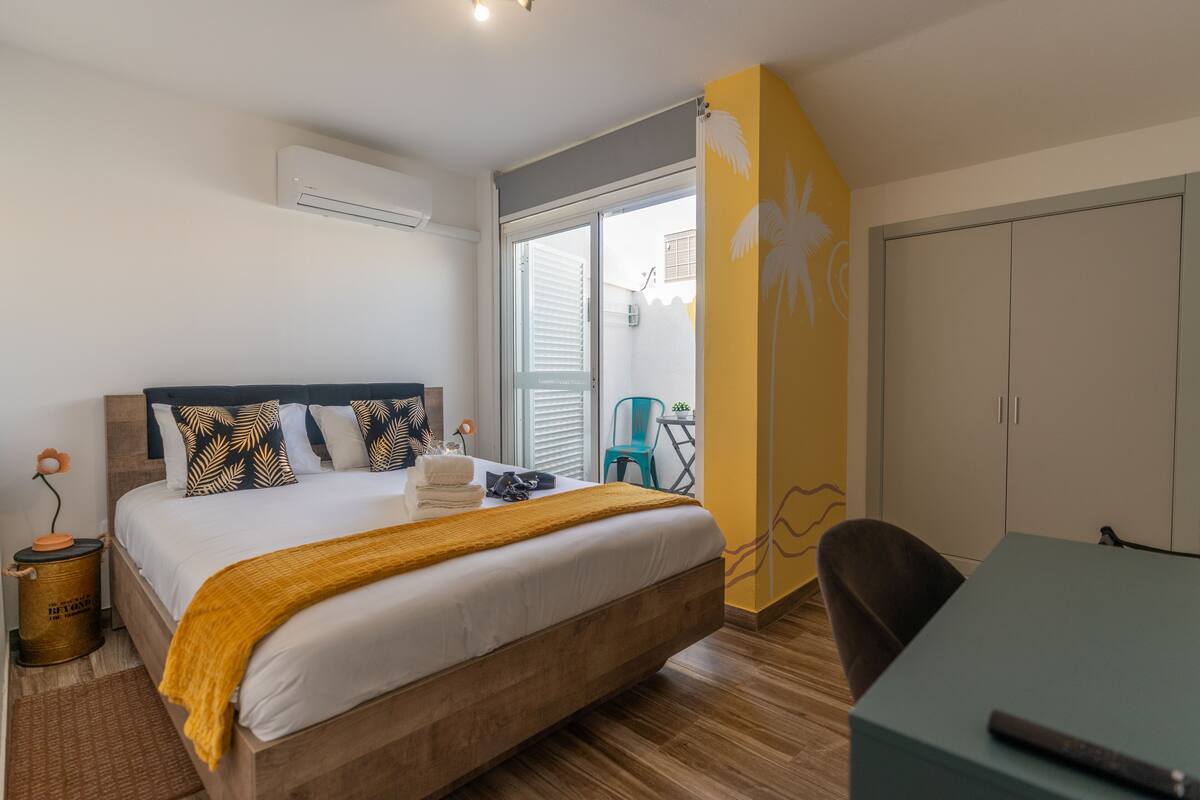 A bedroom with a bed, a desk, a chair, and a wardrobe.