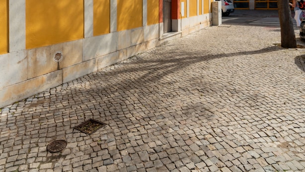 Una calle adoquinada con un edificio amarillo que muestra un cartel 'Levin'.